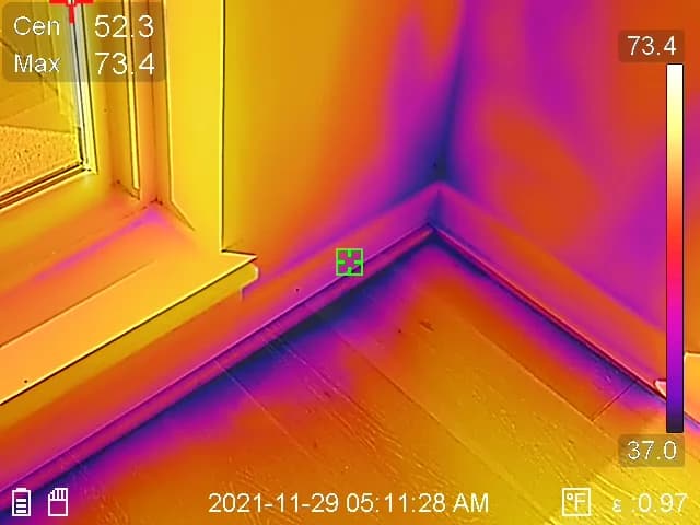 Thermal image of a room corner showing temperature differences along the wall and floor